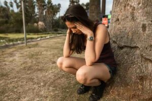 A person experiencing diabetes burnout while looking at their glucose monitoring device.